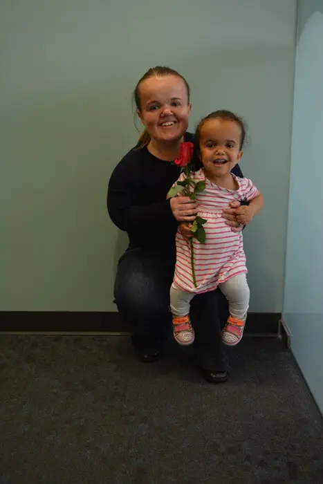Mother and child posing after receiving a Mother's Day rose at Alexandria Children's Dentistry