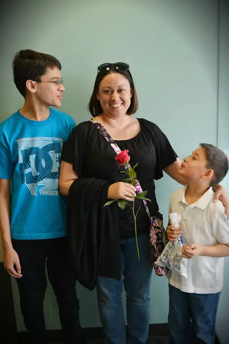 Child presenting a Mother's Day rose after an appointment at Alexandria Children's Dentistry