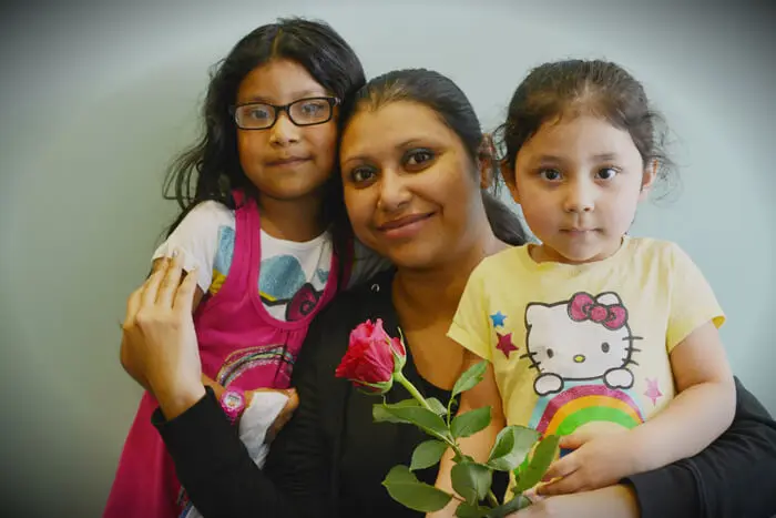 Mother and children posing with Mother's Day roses at Alexandria Children's Dentistry