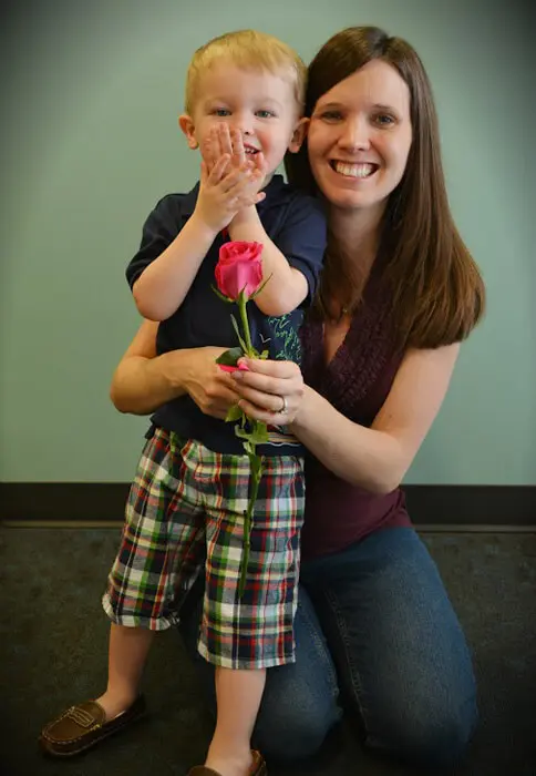 Mother and child smiling with a Mother's Day rose from Alexandria Children's Dentistry