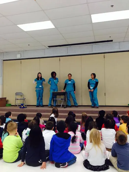 Alexandria Children's Dentistry team presenting an oral health demonstration to elementary students