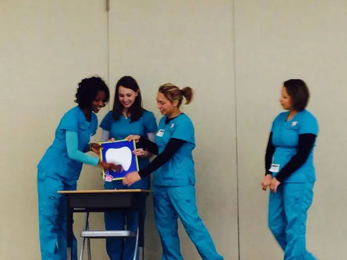Alexandria Children's Dentistry team demonstrating proper brushing techniques during a school visit