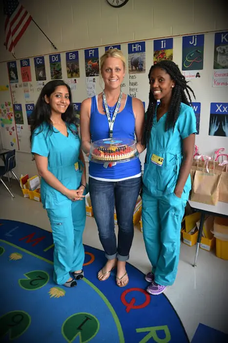 Alexandria Children's Dentistry staff celebrating Mother's Day with a patient and flowers
